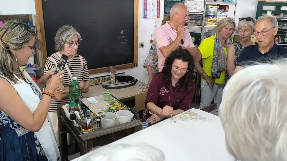 Tutor durante la dimostrazione di decorazione della pietra lavica Tutor durante la dimostrazione di decorazione della pietra lavica