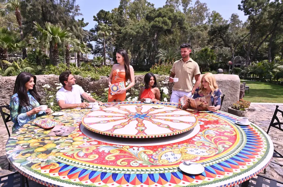 Gruppo nel giardino Artesole intorno a un tavolo circolare in pietra lavica decorata Gruppo nel giardino Artesole intorno a un tavolo circolare in pietra lavica decorata