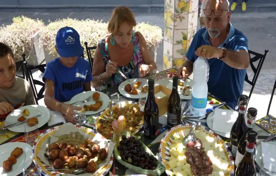 Ospiti riuniti intorno alla tavola durante una pausa conviviale presso Artesole Ospiti riuniti intorno alla tavola durante una pausa conviviale presso Artesole