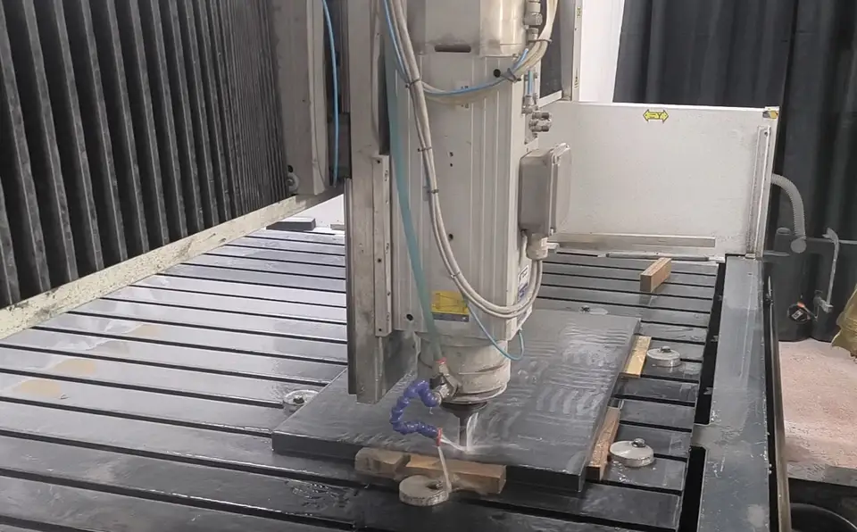 Macchinario CNC durante la lavorazione di una lastra in pietra lavica