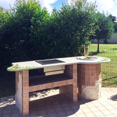 Barbecue in finta muratura con top in pietra lavica decorata a mano