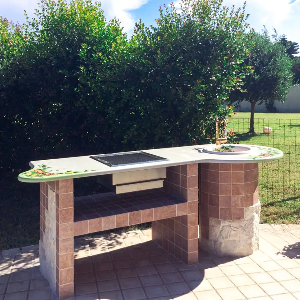 Barbecue in finta muratura con top in pietra lavica decorata a mano