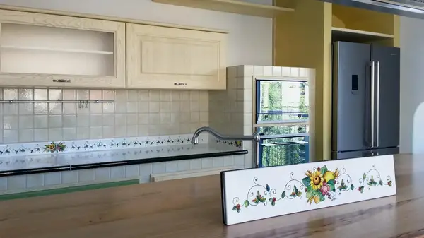 Cucina Moderna: isola con piano colazione in legno e pannello floreale decorato