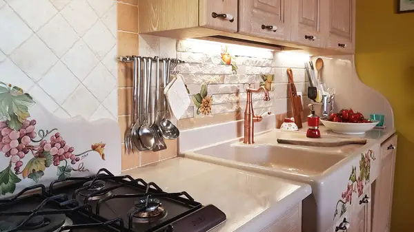 cucina in finta muratura con lavello in pietra lavica decorato a mano