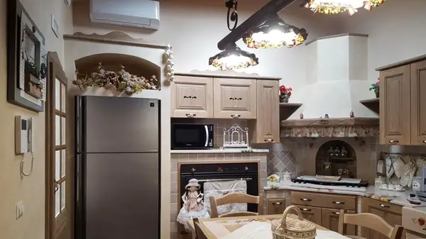 Cucina antica angolare realizzata su progettazione, frigo incassato, piano cottura angolare
