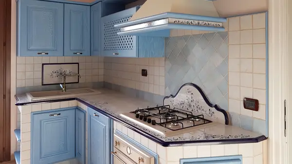 Cucina Classica: zona cottura angolare Cucina Classica: zona cottura angolare con ante azzurre e top decorato