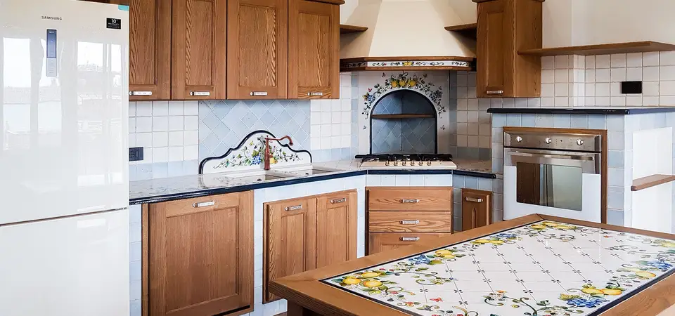 Cucina in finta muratura Liberty con ante in legno e tavolo coordinato in pietra lavica decorata