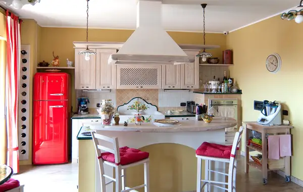 Cucina in finta muratura New Style: composizione con isola curva, ante chiare e cappa sospesa