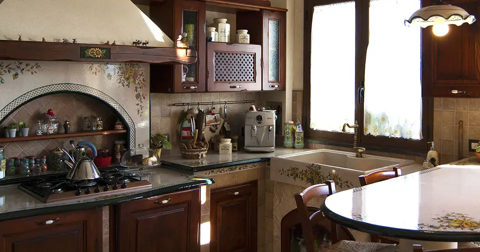 Cucina Treviso: ante in legno scuro Cucina in finta muratura Treviso con ante in legno scuro e nicchia ad arco sotto la cappa decorata