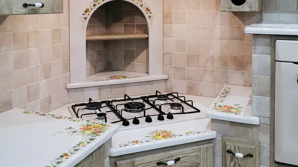 Cucina Venezia: piano cottura angolare sotto la nicchia ad arco con top floreale