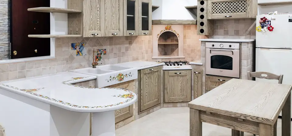 Cucina in finta muratura Venezia con ante in legno chiaro e penisola in pietra lavica decorata