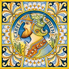 Mattonella decorata con un ritratto maschile di profilo con elmo decorato, la scritta Carpe Diem e una cornice floreale blu, bianca e gialla
