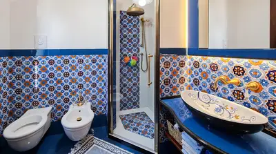 Bagno con rivestimento in pietra lavica decorata