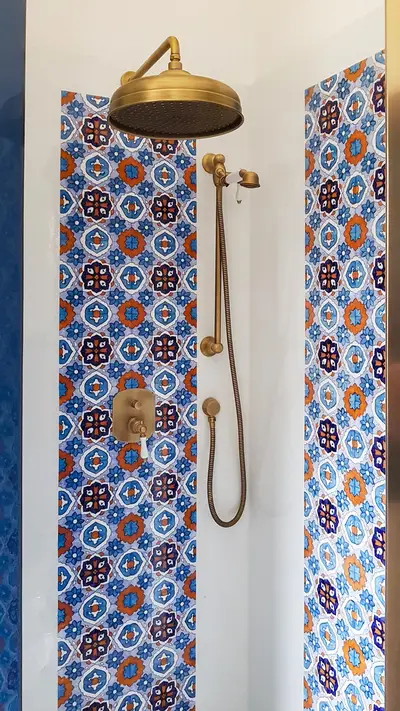 Zona doccia con rivestimento in pietra lavica decorata a mano