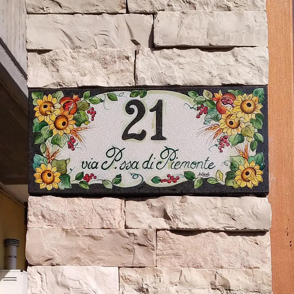 Numero civico in pietra lavica decorata a mano con girasoli e melograni