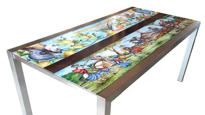 Tavolo in pietra lavica con Pupi Siciliani e inserto in legno, vista della base in metallo e dei due pannelli decorati.