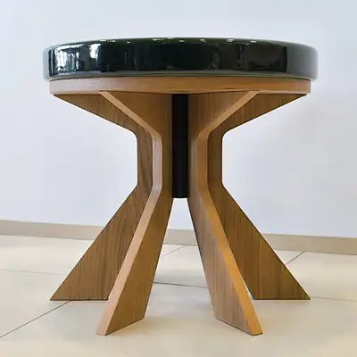 Tavolino rotondo con spesso piano in pietra lavica verde scuro e base sagomata in legno
