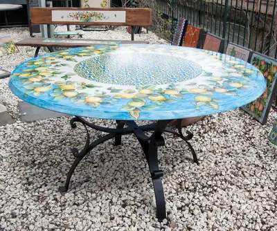 tavolo da giardino in pietra lavica con decoro limoni e base in ferro battuta