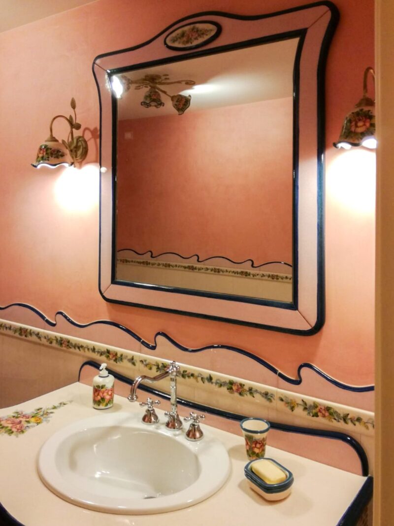 Bagno con specchiera realizzati in pietra lavica decorata a mano